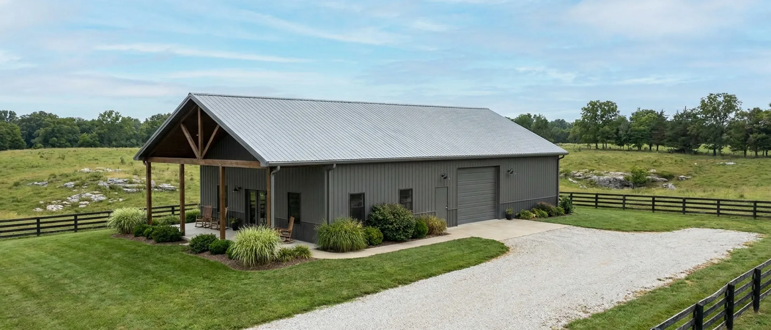 A completed barndominium with a covered entry porch and an attached shop bay, photographed in flat overcast daylight.
